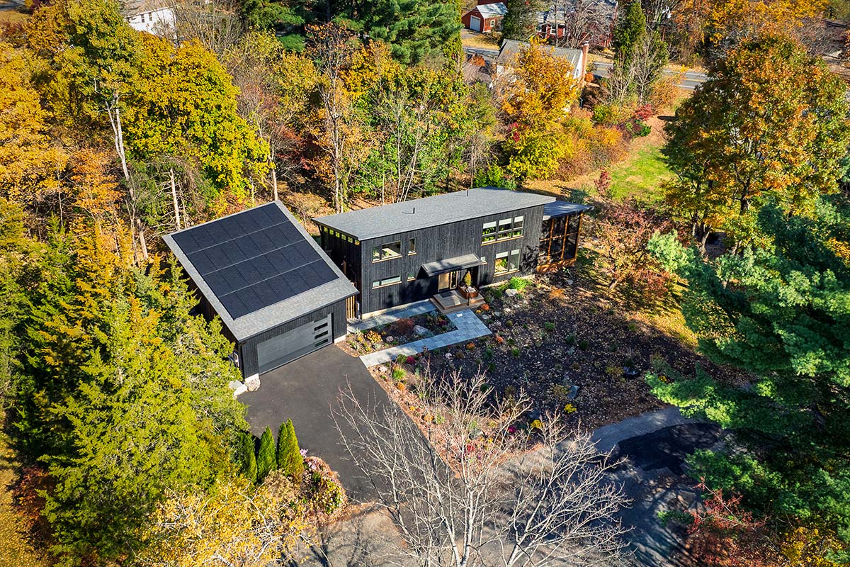 Modern accessory dwelling unit (ADU) with black vertical siding, screened porch, and warm wood accents, custom built in Amherst, Massachusetts.