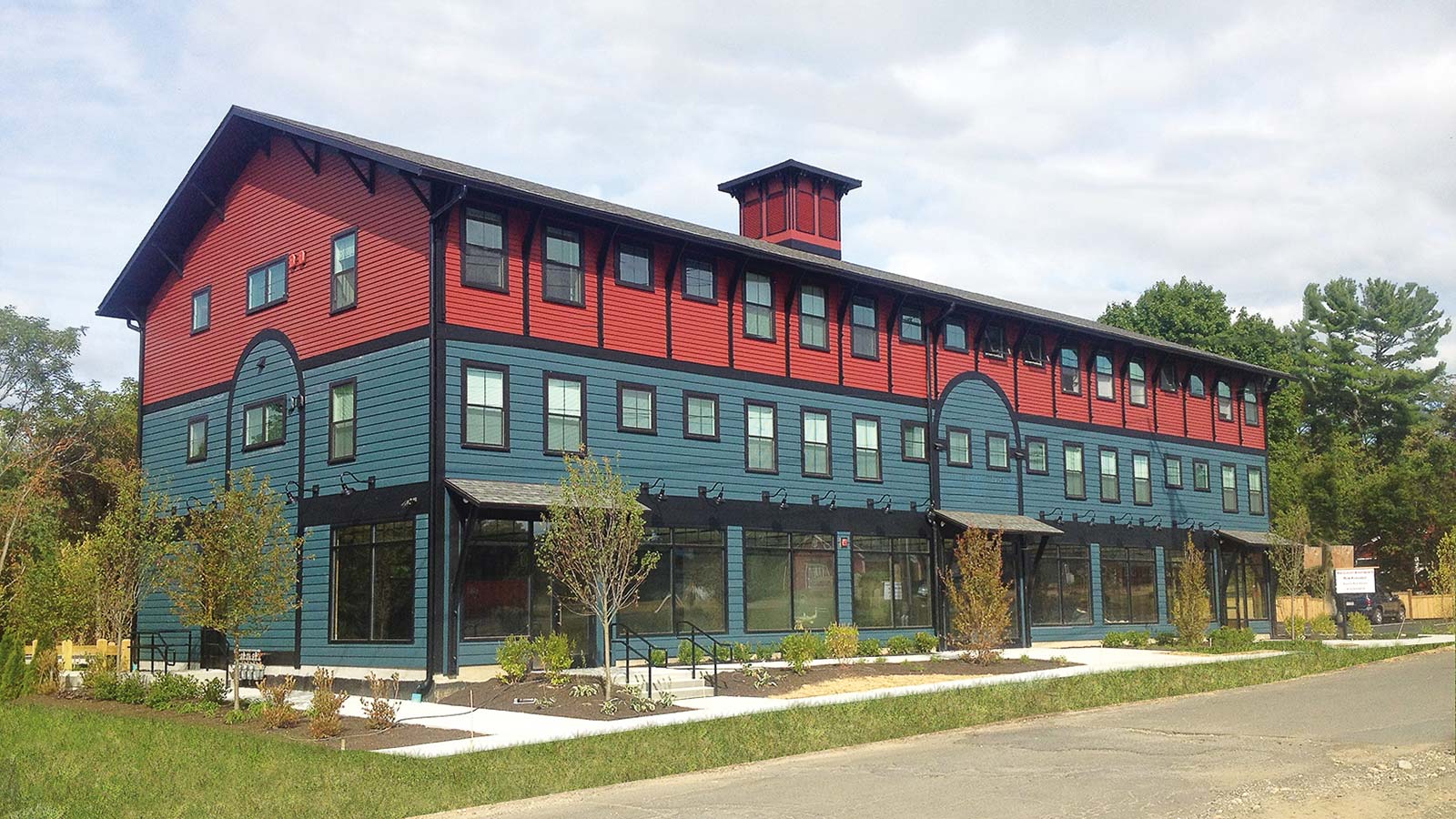 Three-story mixed-use commercial and residential building in Amherst, MA, featuring ground-floor retail space and upper-level apartments.